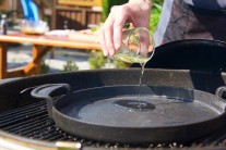 Do grilu Weber One-Touch jsme použili těžkou litinovou pánev BBQ. Na pánev nalijeme trochu oleje a necháme řádně prohřát. Zkoušku teploty provedeme vhozením jednoho kousku do oleje na pánvi. Pokud se začne hned smažit, je olejdost rozehřátý a my můžeme přidat ostatní naložené maso.